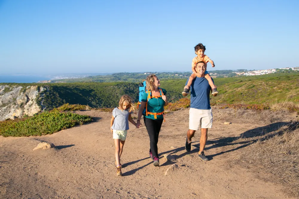 Familie în drumeție pe munte, acoperită de asigurarea de călătorie pentru activități sportive
