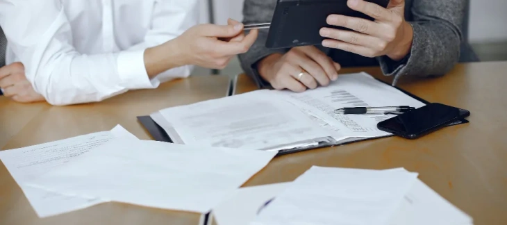 Doi consultanți care pregătesc depunerea electronică a dosarului pe portalul Registrului Comerțului