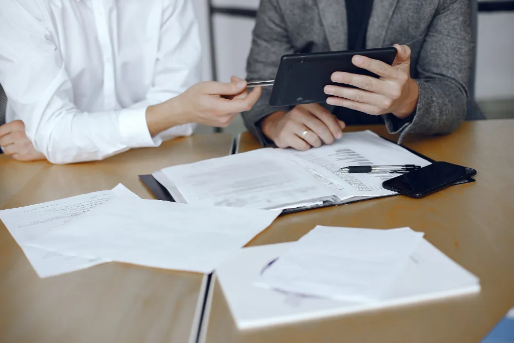 Doi consultanți care pregătesc depunerea electronică a dosarului pe portalul Registrului Comerțului