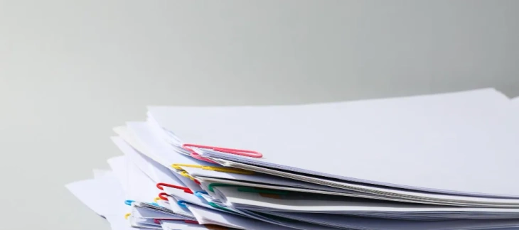 Teanc de documente prinse cu agrafe, pregătite pentru dosarul de mențiuni depus la Registrul Comerțului